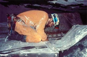 Photo of Miner on job, crouched over with poor ergonomics